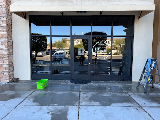 DePalmas Residential Services performing professional window cleaning on a commercial storefront in Mesa, Arizona